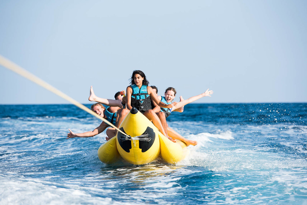 Internationale junge Reisende auf einer MedSailors Segelreise in Griechenland haben Spaß auf einem Banana Boat