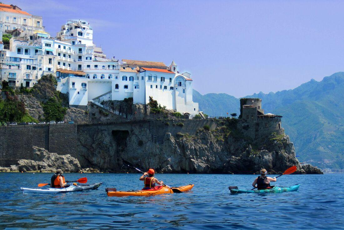 Kleine internationale Reisegruppe macht Kajaktour entlang der Küste bei Intrepid Travel