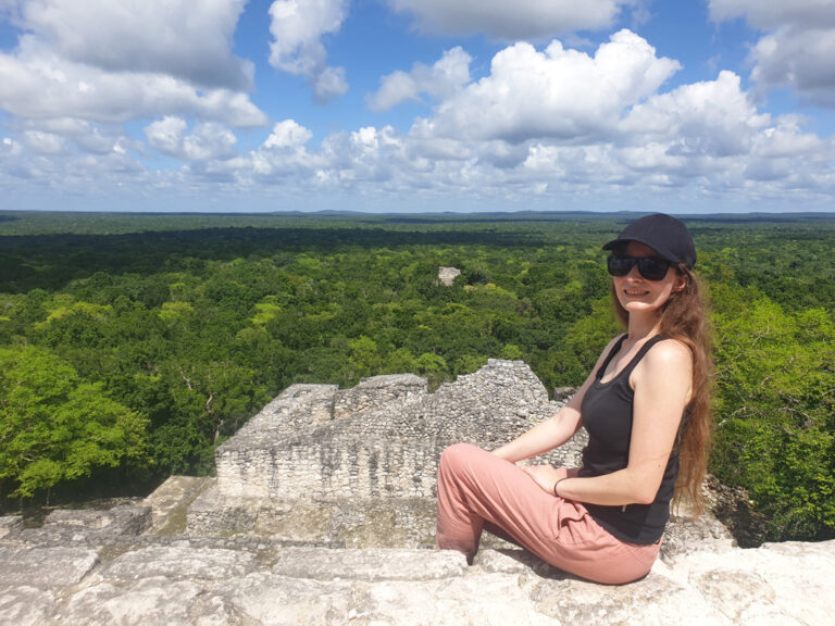 Reisende sitzt auf Maya Ruine im im Dschungel
