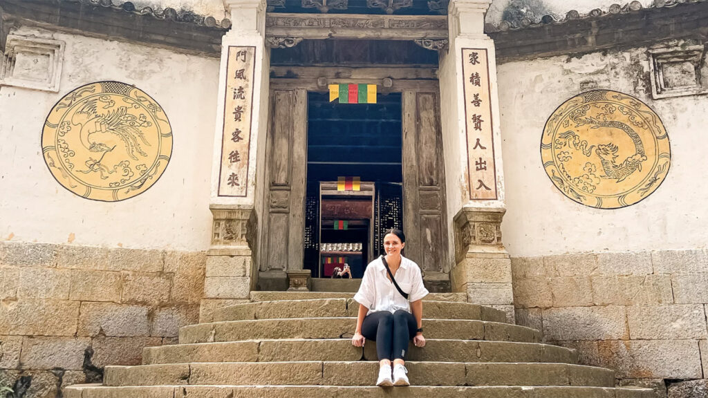 Reisende sitzt auf den Treppenstufen vor einem Tempel