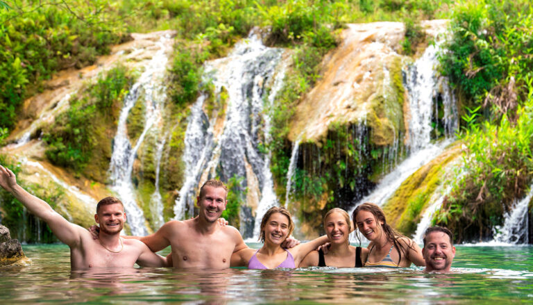 Gruppenbild im Wasser vor einem Wasserfall