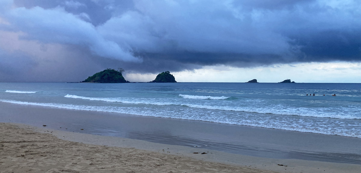 Nacpan Beach mit Regenwolken, Gruppe im Wasser