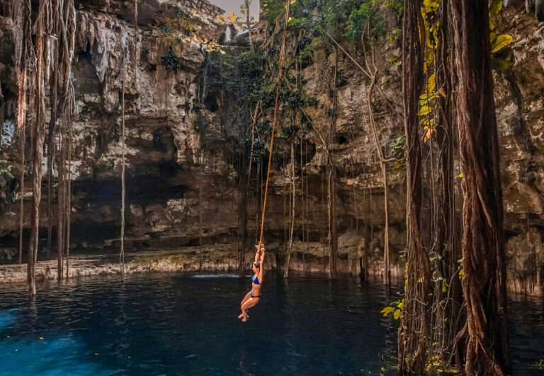 Reisende schwingt über dem Wasser einer Cenote