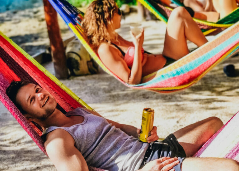 Reisende in Hängematten am Strand