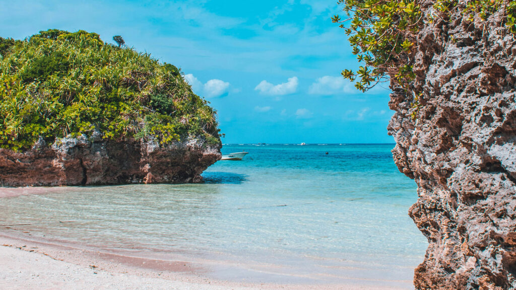 Strand, Meer und bewachsene Felsen auf der Insel Ishigaki