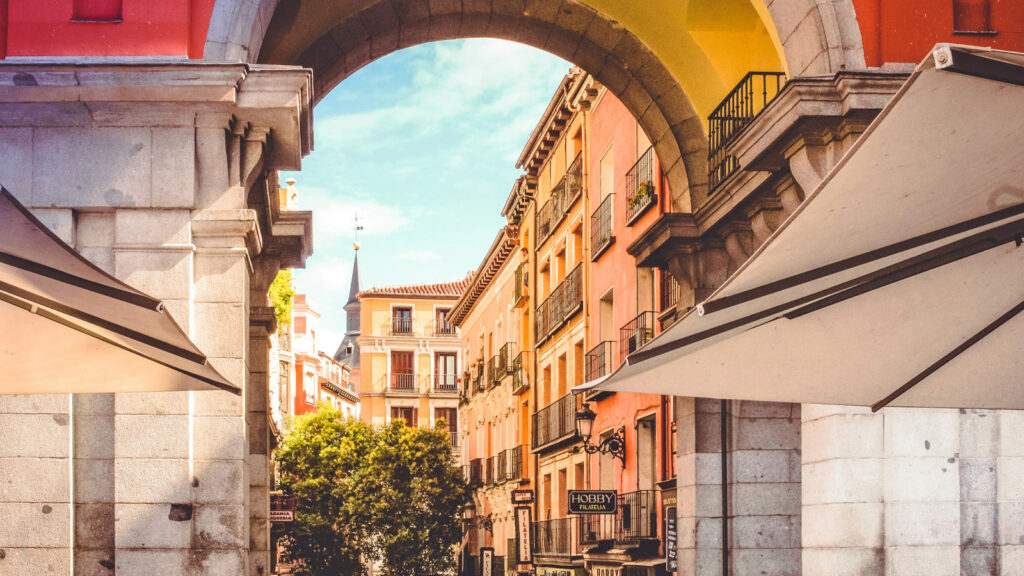 Blick durch Torbogen auf bunte Häuser in Madrid