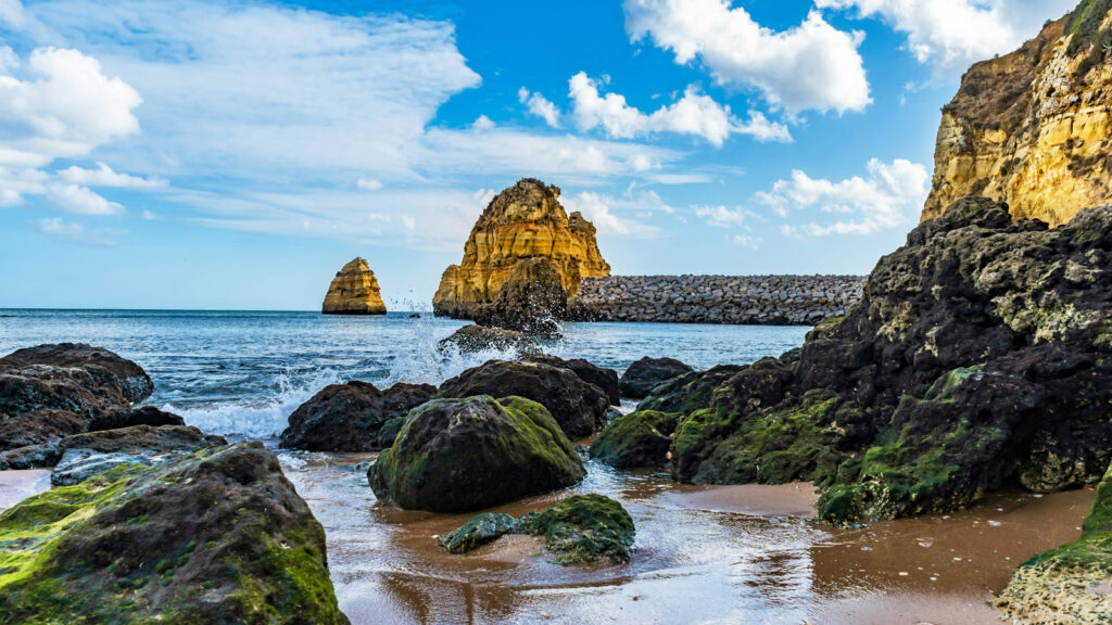 Blick von kleinem Strand auf Felsen und Meer in Lagos an der Algarve