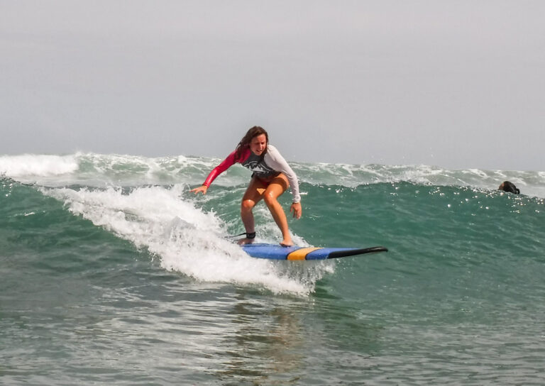 Surferin nimmt eine kleine Welle
