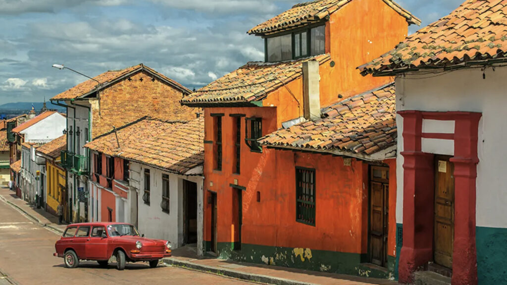 Altes Auto vor bunten Häusern am Hang