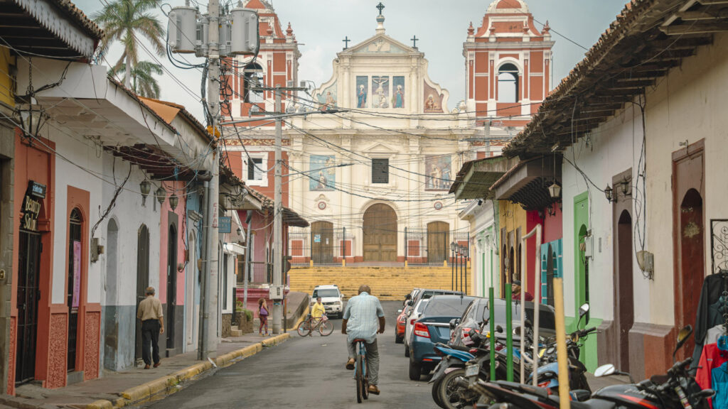 Mann auf Fahrrad fährt auf Kirche in Leon zu