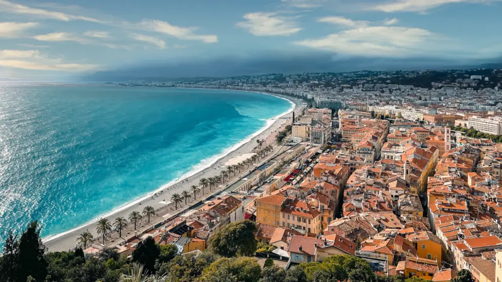 Luftaufnahme von Nizza an der Côte d’Azur mit Strand, Altstadt und türkisblauem Mittelmeer, ideal für Gruppenreisen junger Leute in Europa