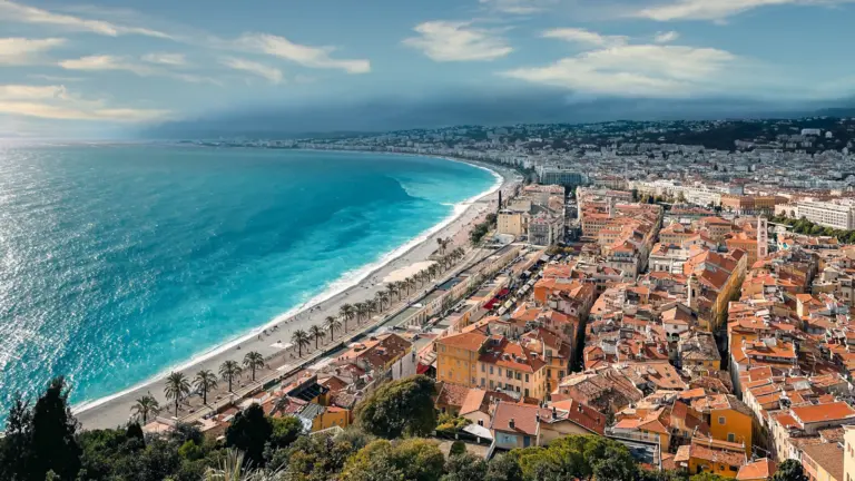 Luftaufnahme von Nizza an der Côte d’Azur mit Strand, Altstadt und türkisblauem Mittelmeer, ideal für Gruppenreisen junger Leute in Europa
