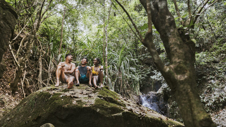 3 junge Leute vor Wasserfall im Dschungel auf den Philippinen