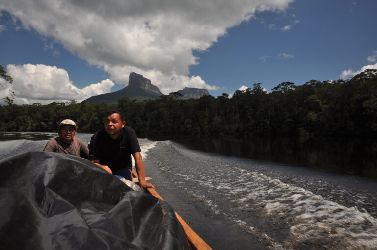 Zwei Männer auf einer Curiara auf einem Fluss im venezolanischen Dschungel