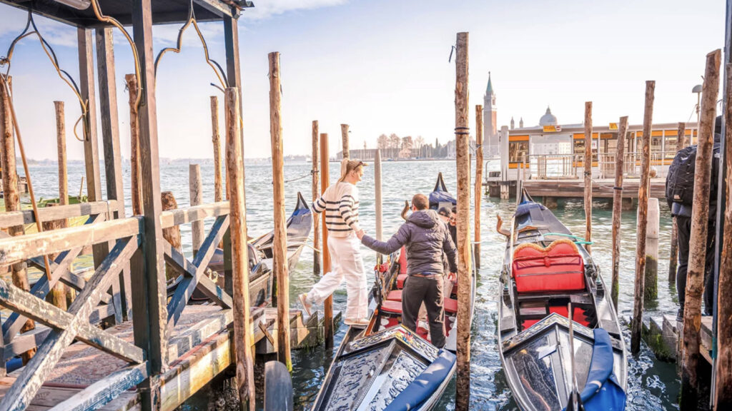 Junge Frau steigt in Gondel in Venedig ein