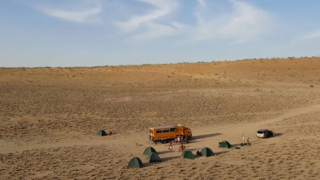 Overland-Truck und Zelte in der Karakum-Wüste in Turkmenistan während einer Abenteuerreise durch Zentralasien