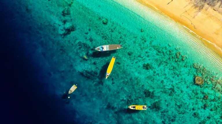 Luftaufnahme von Booten im türkisblauen Meer vor Gili Trawangan in Indonesien – Inselhopping Reise Bali Lombok Komodo