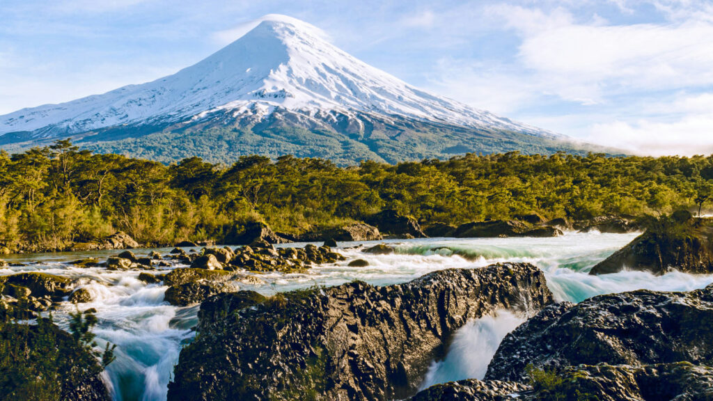 Wasserfall vor schneebedecktem Vulkan in Puerto Varas, Chile