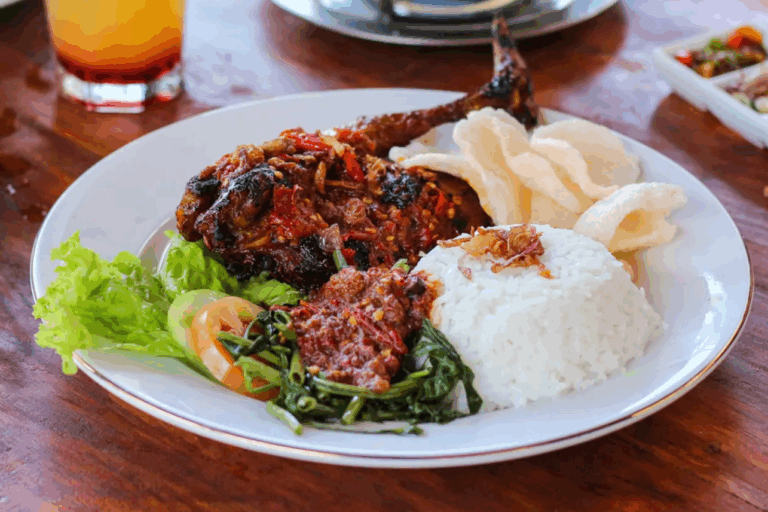 Traditionelles indonesisches Gericht mit Reis, Hähnchen in Sambal-Sauce und Gemüse – kulinarisches Erlebnis während eines Raja Ampat Urlaubs