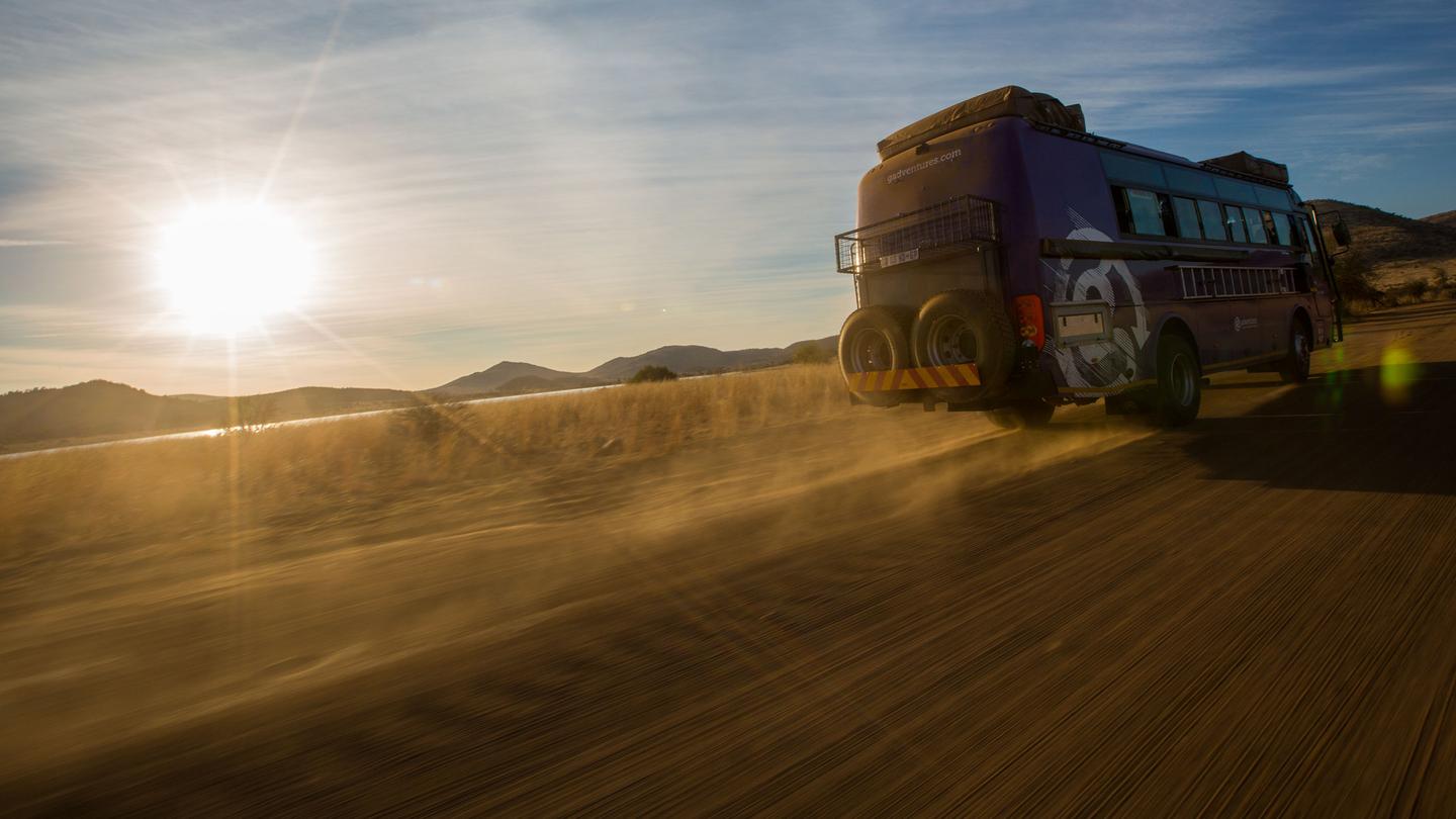 Overland-Truck von G Adventures in weiter Natur bei Sonnenuntergang, symbolisch für nachhaltige, organisierte Abenteuer- und Gruppenreisen, buchbar über traveljunkies mit deutscher Beratung und persönlichem Kundenservice.