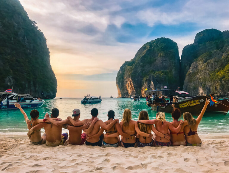 Gruppe am Strand blickt auf die Maya Bay und den Sonnenuntergang