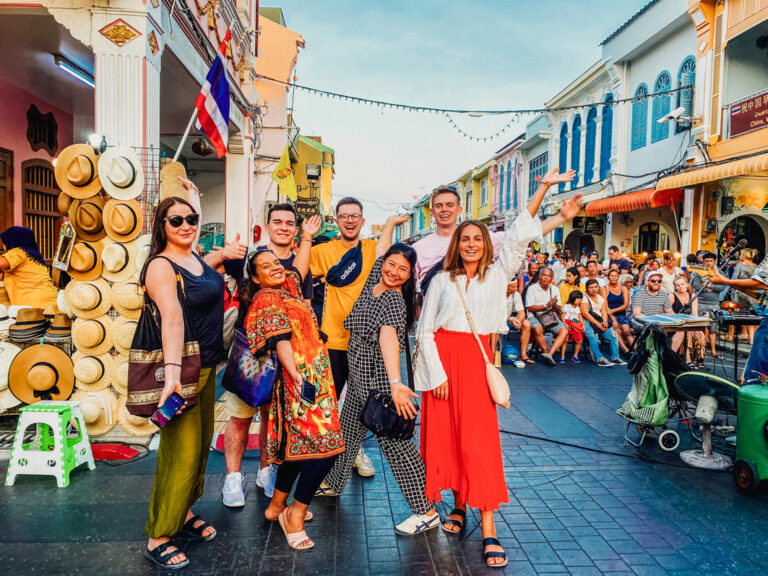 Gruppe in erster Straße mit Geschäften und Kolonialhäusern