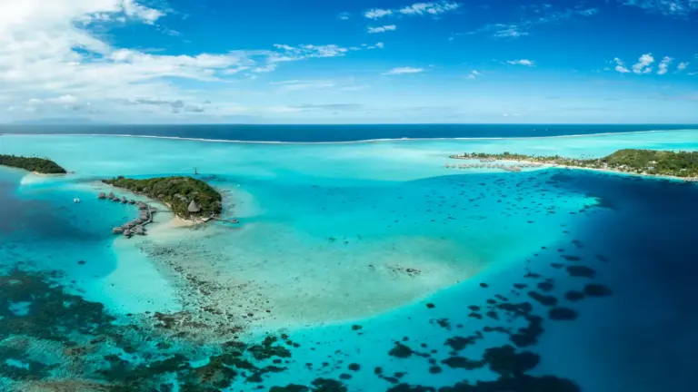 Luftaufnahme von Bora Bora mit türkisfarbener Lagune und kleinen Inseln in Französisch Polynesien