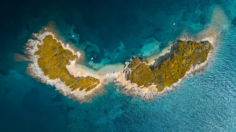 Luftaufnahme von Ksamil in Albanien mit türkisblauem Meer, kleinen Inseln und weißen Stränden an der Albanischen Riviera