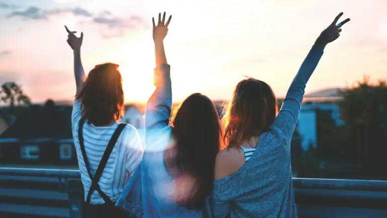 Junge Erwachsene genießen gemeinsam den Sonnenuntergang auf einer Gruppenreise in Europa