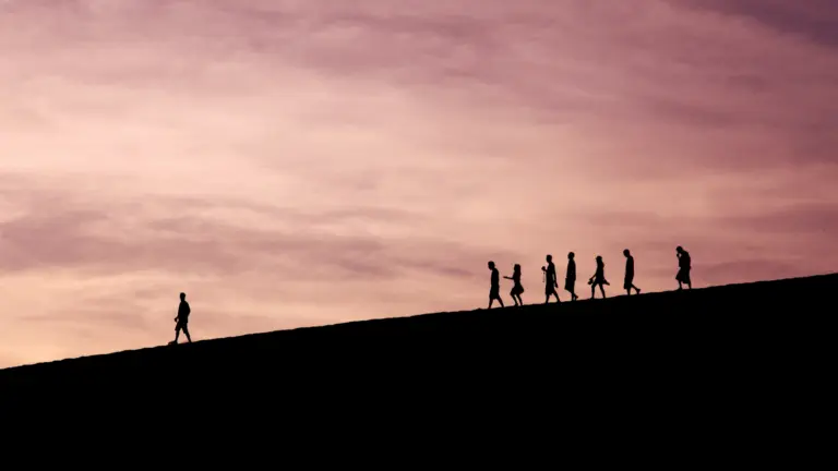 Gruppe junger Erwachsener wandert gemeinsam bei Sonnenuntergang in der Natur als Symbol für Gruppenreisen weltweit