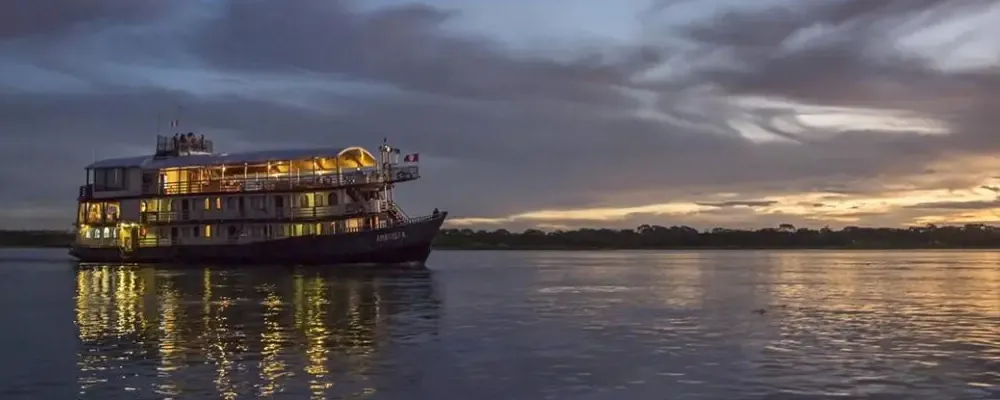 Luxuriöses Amazonas-Kreuzfahrtschiff bei Sonnenuntergang auf dem Amazonas in Peru, komfortable Flusskreuzfahrt durch den Regenwald