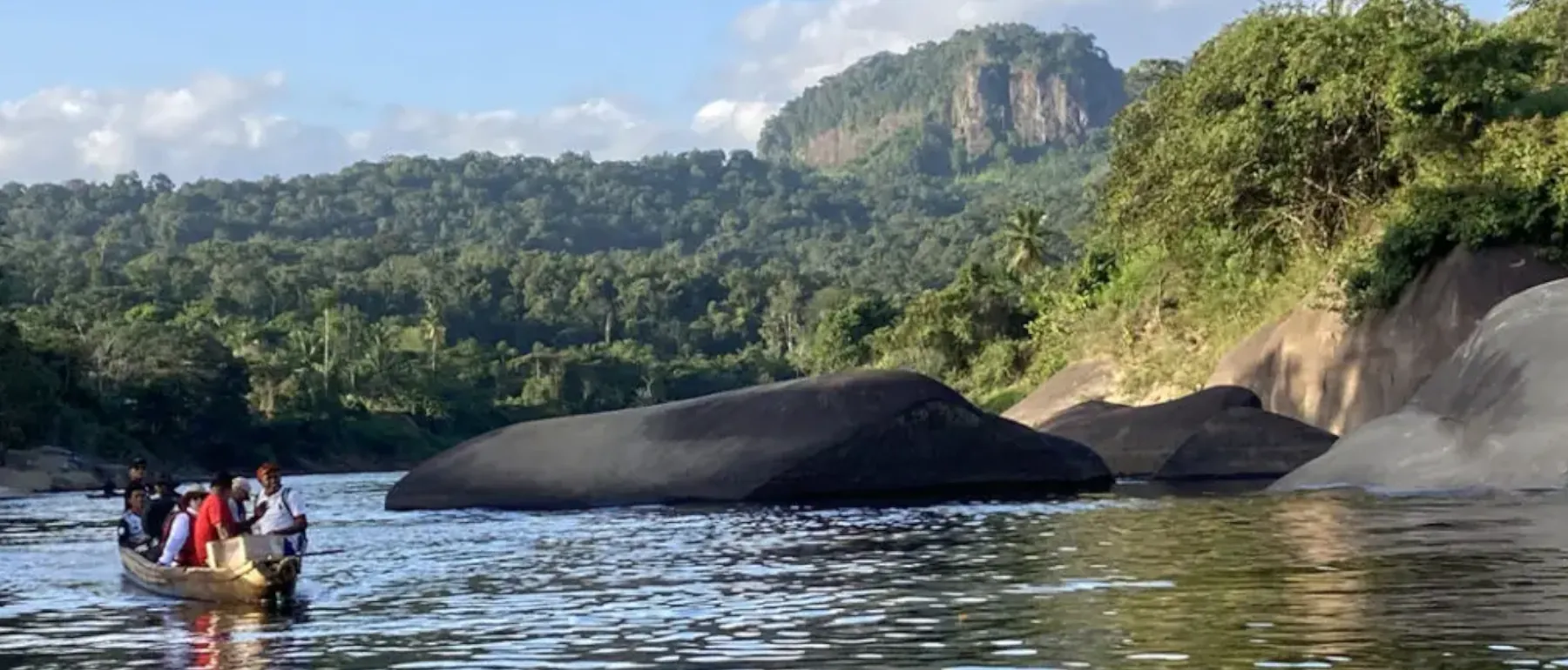 Einbaum auf einem Fluss vor einem Tepui in den Guyana Highlands während einer Trekking Expedition