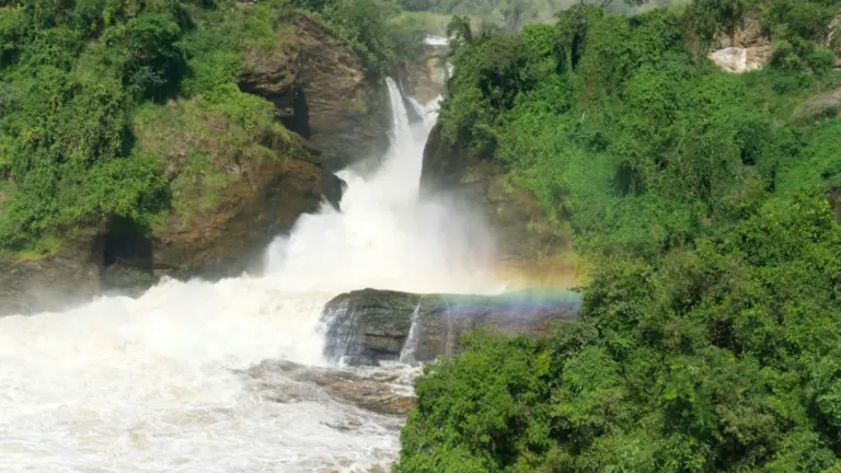 Murchison Falls in Uganda mit dem Nil zwischen grünen Felswänden und Regenbogen