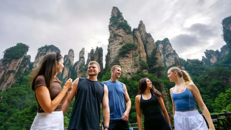 Junge Reisegruppe vor den spektakulären Sandsteinsäulen der Zhangjiajie Avatar Mountains auf einer China Erlebnisreise