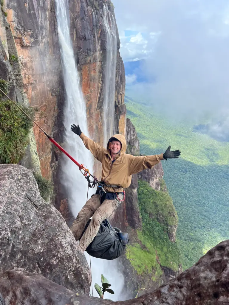 Abenteurer mit Klettergurt und Sicherungsseil beim Abseilen an der Felswand neben dem Salto Ángel in Venezuela