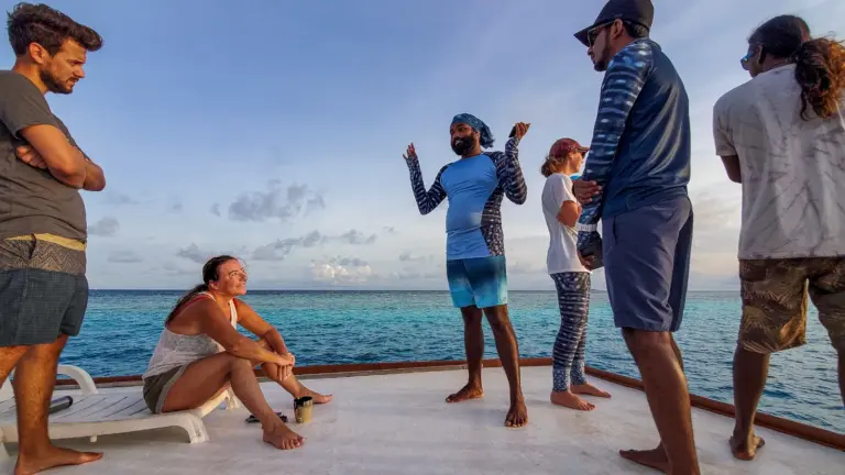 Teilnehmer einer Walhai Expedition beim Briefing mit einem Meeresforscher an Bord eines Schiffes im Süd Ari Atoll auf den Malediven