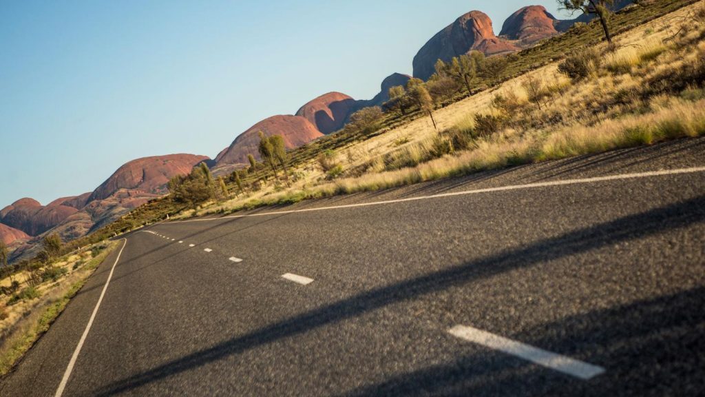Straße zum Ayers Rock/Uluru im Northern Territory in Australien. traveljunkies Reisen für junge Leute